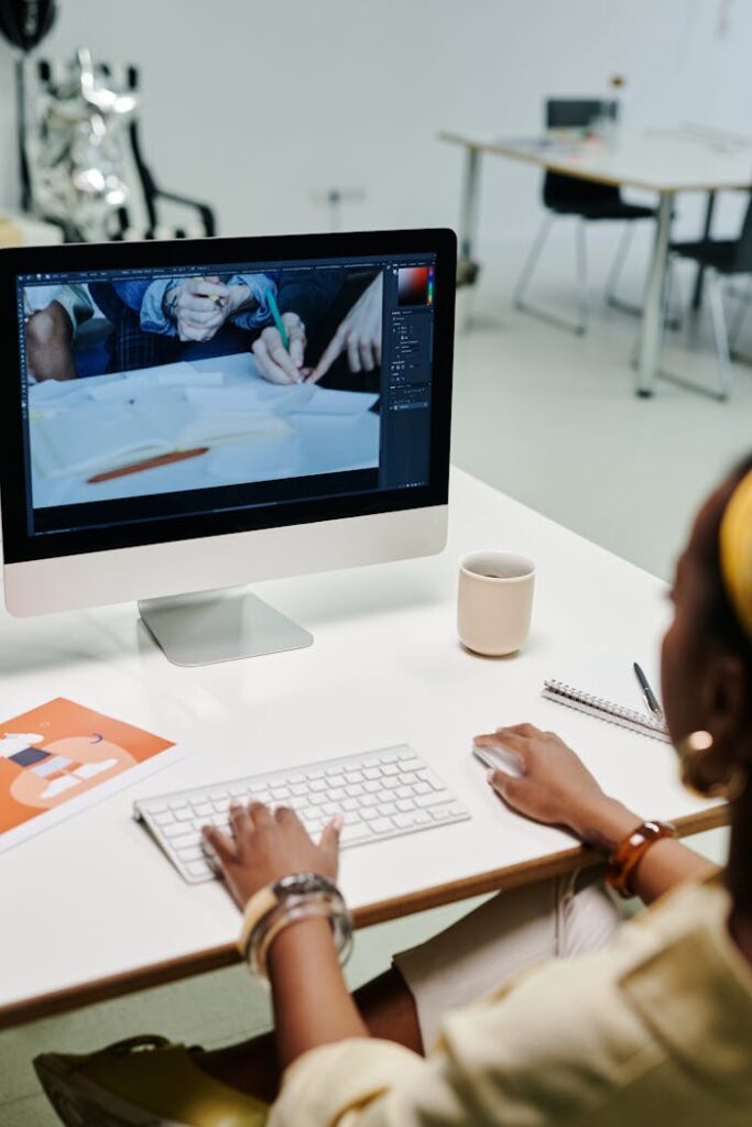 A designer working on an iMac in a modern office setting, showcasing creativity and productivity.